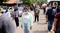 Ratusan masyarakat yang mengikuti vaksin Covid-19 berdiri mengheningkan cipta sejenak memperingati HUT ke-76 RI di Jakarta, Selasa (17/8/2021). Hal tersebut dilakukan untuk mengenang jasa para pahlawan dalam memperjuangkan Kemerdekan Republik Indonesia. (Liputan6.com/Angga Yuniar)