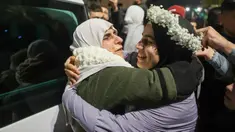 Tahanan Palestina, Baraah Fuqaha (kanan) disambut oleh kerabatnya pada saat kedatangan pada dini hari tanggal 20 Januari 2025 di kota Tepi Barat yang diduduki, Beitunia, di pinggiran kota Ramallah. (Zain JAAFAR/AFP)