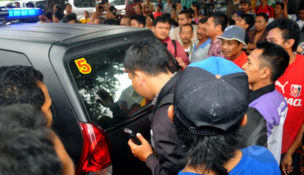 Sejumlah warga yang penasaran ingin melihat wajah pelaku pembunuhan Deudeuh Alfi Sahrin alias Tata Chubby di Tebet saat berada didalam mobil tahanan, Jakarta, Jumat (17/4/2015). (Liputan6.com/Yoppy Renato)
