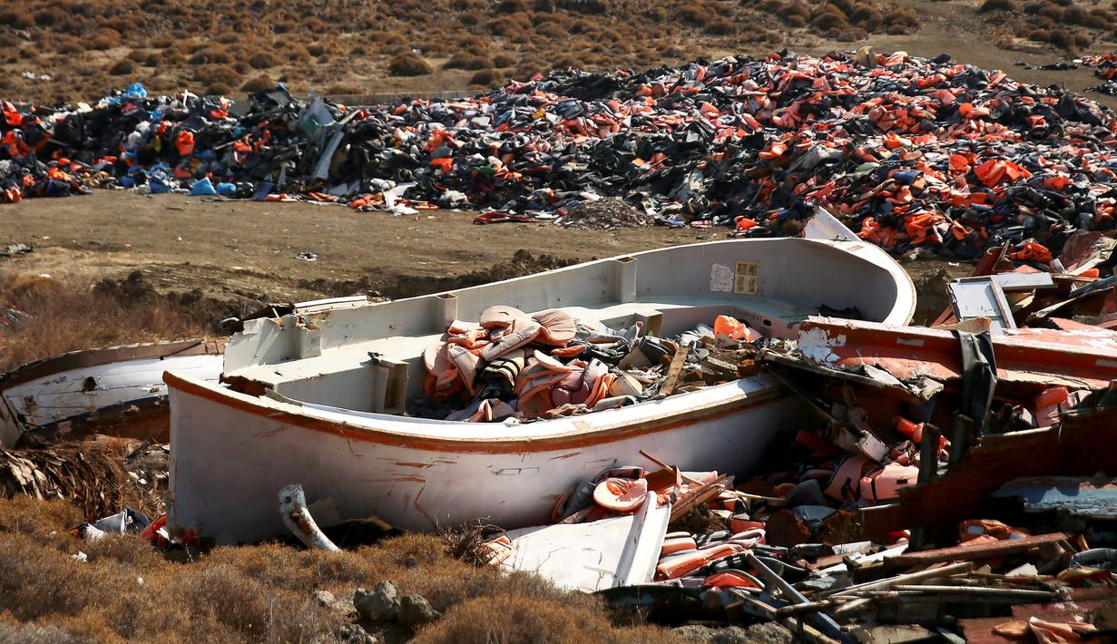 Jaket pelampung terlihat didalam perahu rusak yang digunakan para imigran, di tempat pembuangan sampah di Mithymna, pulau Lesbos, Rabu (5/10). Para imigran mendarat di Yunani untuk mencari kehidupan baru di Eropa. (REUTERS/Alkis Konstantinidis)