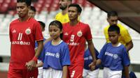 Pemain Persija Jakarta, Novri Setiawan, memasuki lapangan Stadion Utama Gelora Bung Karno, Senayan, ditemani Keyshia, satu dari 22 player escort dari Allianz dalam pertandingan Piala AFC 2019 kontra Ceres Negros, Selasa (23/4/2019). (Bola.com/Vitalis Yogi Trisna)