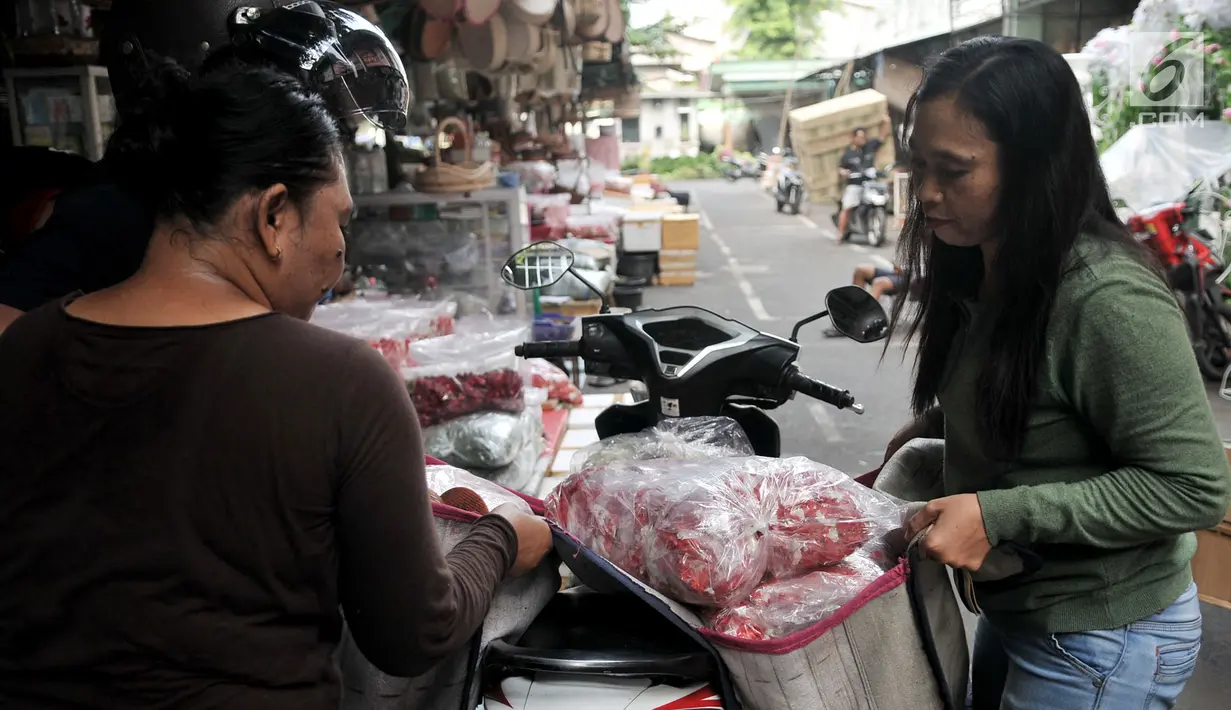 Pedagang mengangkut karung berisi kembang makam yang diborong pengecer di Pasar Rawa Belong, Jakarta, Senin (29/4). Musim ziarah kubur atau nyekar jelang Ramadan meningkatkan omzet pedagang kembang makam di Pasar Rawa Belong. (merdeka.com/Iqbal Nugroho)