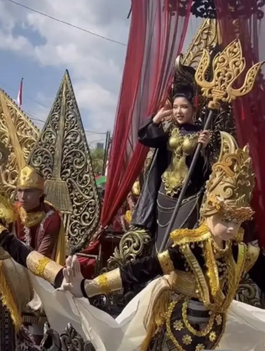 Kali ini Tiara Andini juga terlihat begitu spektakuler dengan gaun hitam emas. Ia tampak seoperti seorang dewi yang memikat.  [Foto: Instagram/ Jember Fashion Carnaval]
