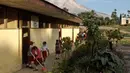 Murid menyapu saat Gunung Sinabung mengeluarkan abu vulkanik di sebuah sekolah dasar di Beganding, Sumatra Utara, (20/2). (AP Photo / Ahmad Putra)