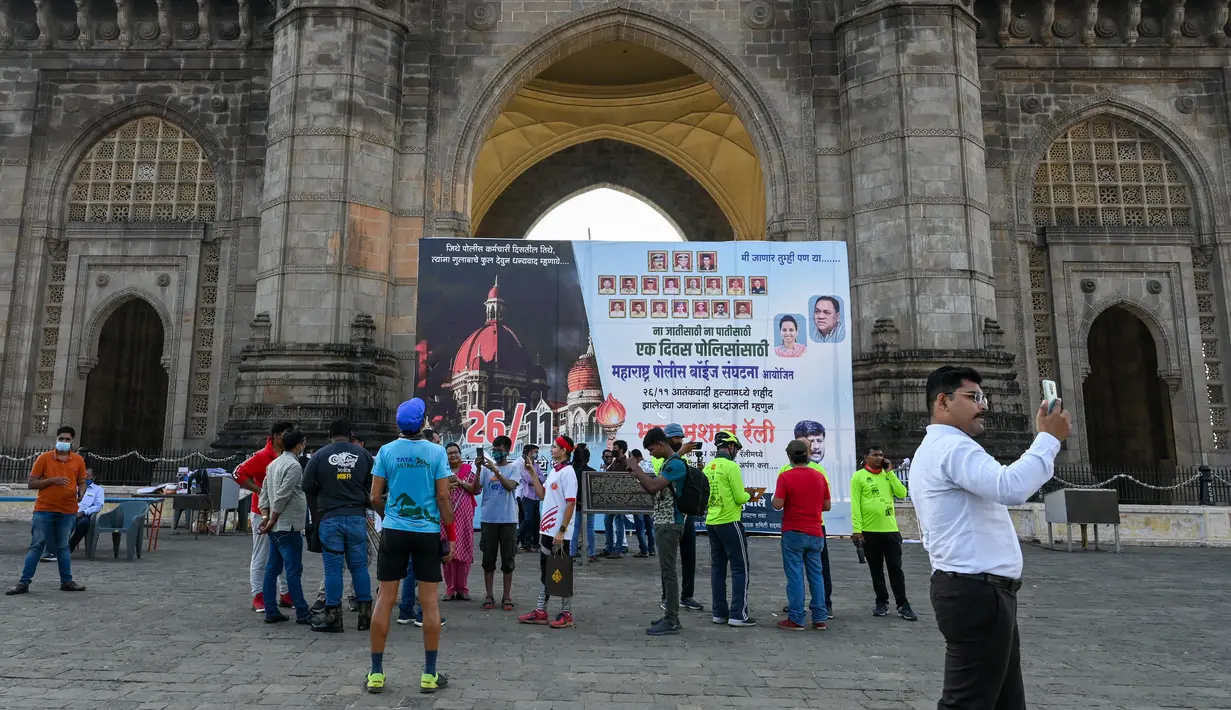 Orang-orang berkumpul di dekat Gerbang India untuk memberikan penghormatan kepada para korban serangan teroris 2008 pada peringatan 13 tahun di Mumbai (26/11/2021). Peristiwa teror terjadi selama 60 jam itu terjadi di hotel mewah, stasiun kereta api, dan pusat kebudayaan Yahudi. (AFP/Punit Paranjpe)