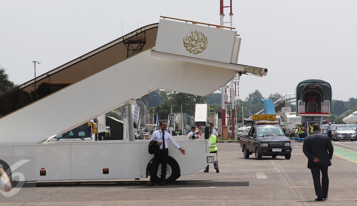 Petugas berdiri dekat eskalator pribadi yang diboyong dari Arab Saudi, di appron Bandara Halim Perdana Kusuma, Jakarta, Rabu (1/3). Eskalator milik Raja Salman itu berwarna putih dan dihiasi kaligrafi emas di bagian atas. (Liputan6.com/Fery Pradolo)