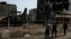 Petugas berdiri di dekat kawat berduri yang mengelilingi lokasi jatuhnya pesawat Hercules C-130, di Jalan Jamin Ginting, Medan, Sumut, Kamis (2/7/2015). Untuk mensterilisasi lokasi, petugas memasang barikade kawat berduri. (Liputan6.com/Johan Tallo)