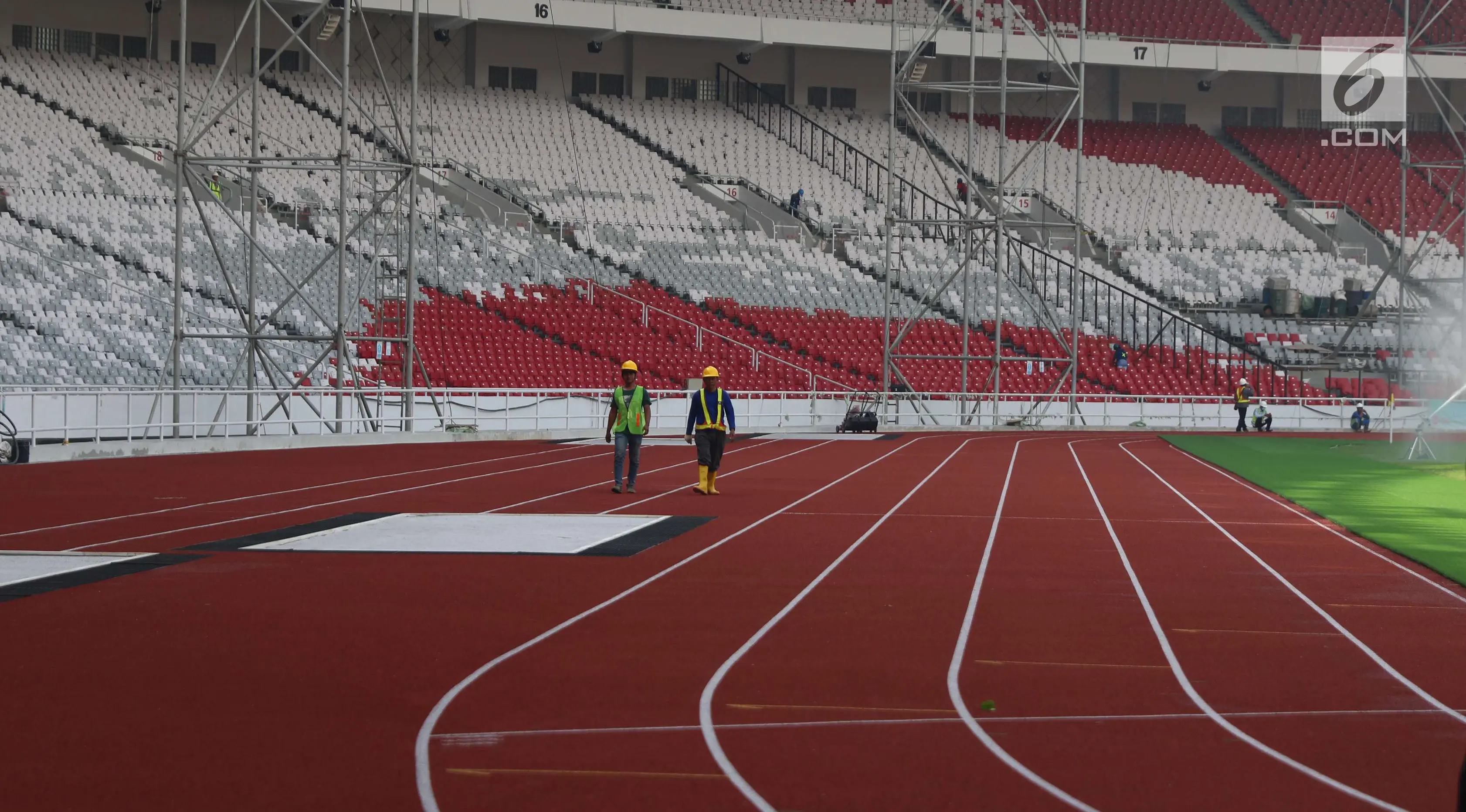 Pekerja berjalan di lintasan lari Stadion Utama Gelora Bung Karno, Jakarta, Kamis (23/11). Renovasi yang akan digunakan pada ajang Asian Games XVIII itu diperkirakan pada Februari 2018 sudah dapat digunakan untuk "test event". (Liputan6.com/Angga Yuniar)
