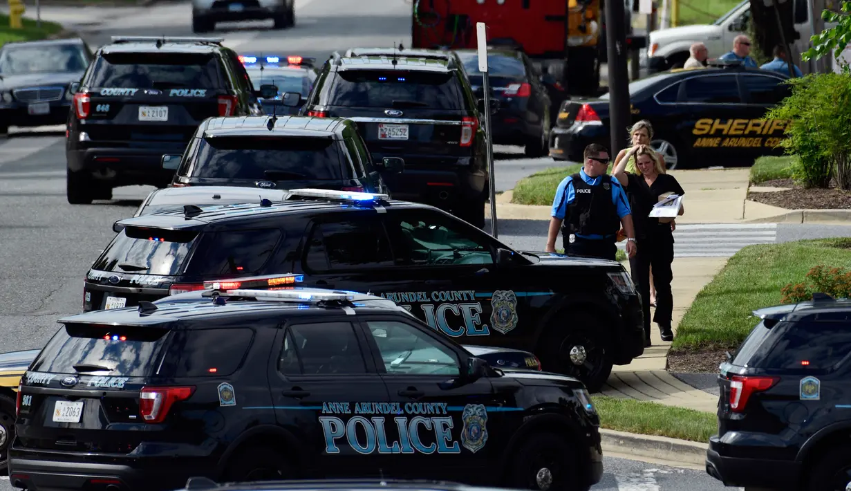 Aparat kepolisian mengamankan lokasi penembakan brutal di kantor surat kabar lokal Capital Gazette di Annapolis, Amerika Serikat (AS), Kamis (28/6). Akibat penembakan ini lima orang tewas dan tiga lainnya luka parah. (AP/Susan Walsh)