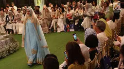 Model membawakan koleksi terbaru Hijab Mandjha milik presenter dan perancang Ivan Gunawan di Jakarta, Rabu (25/4). Peragaan bertema Raya Collection 2018 digelar untuk merayakan usia label ini yang hampir genap setahun.  (Liputan6.com/Immanuel Antonius)