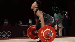 Lifter Indonesia Rahmat Erwin Abdullah saat berlaga dalam cabang olahraga angkat besi 73 kg putra pada Olimpiade Tokyo 2020 di Tokyo, Jepang, Rabu (28/7/2021). Lifter 20 tahun itu kalah bersaing dengan lifter China Shi Zhiyong dan Mayora Pernia Julio Ruben dari dari Venezuela. (AP Photo/Luca Bruno)