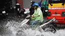 Pengendara motor melintasi banjir usai badai tropis Talas terjadi di Hanoi, Vietnam utara (17/7). Menurut Direktur Pusat Peramalan Nasional Hidro-Meteorologi Badai Talas diprediksi akan melanda provinsi-provinsi utama Vietnam. (AFP Photo/Hoang Dinh Nam)