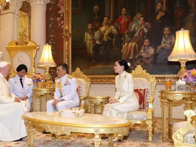 Paus Fransiskus berbincang dengan Raja Thailand Maha Vajiralongkorn (tengah) dan Ratu Suthida (kanan) di Istana Dusit, Bangkok (22/11/2019). Pertemuan dilakukan setelah Paus Fransiskus merayakan misa dengan puluhan ribu umat Katolik Thailand. (Handout/Thai Royal Household Bureau/AFP)