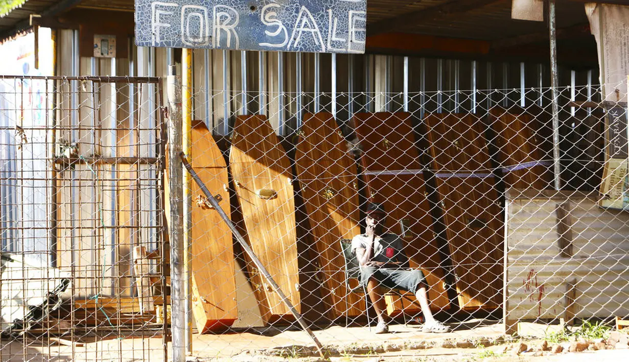 Seorang pekerja perusahaan pembuat peti mati menunggu klien di Harare, Selasa (5/1/2021). Zimbabwe memulai lockdown selama 30 hari dalam upaya untuk mengendalikan lonjakan infeksi COVID-19 yang mengancam petugas kesehatan. (AP Photo/Tsvangirayi Mukwazhi)