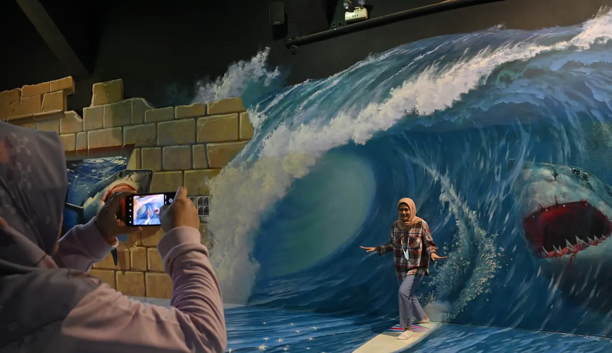 <p>Seorang wanita memfoto rekannya saat mengunjungi museum 3D di Jakarta, Minggu (7/11/2021). Museum 3D tersebut dibuka kembali setelah pelonggaran pembatasan Covid-19. (AFP/Adek Berry)</p>