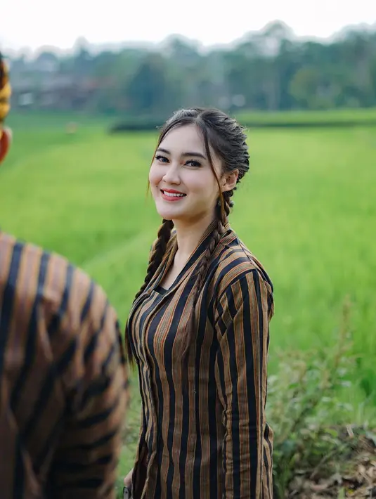 Wanita kelahiran Kediri ini begitu memesona dengan baju lurik khas Jawa serta rambut dikepang dua. Nella juga memoles wajahnya dengan makeup yang tidak terlalu tebal, alhasil wajahnya tambah manis.(Liputan6.com/IG/@nellakharisma)