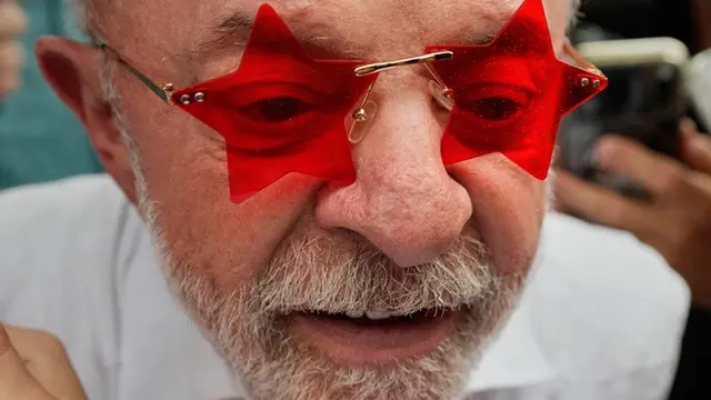 Presiden Luiz Inacio Lula da Silva mengenakan kacamata pemberian seorang pendukungnya setelah memberikan suara dalam putaran kedua Pilpres di Sao Bernardo do Campo, Brasil, Minggu (25/10/2026).