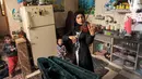 Musisi Palestina Jawaher al-Aqraa memainkan biola sambil berdiri di dapur rumahnya di Deir al-Balah, Jalur Gaza Tengah, 24 Oktober 2023. (Eyad BABA/AFP)