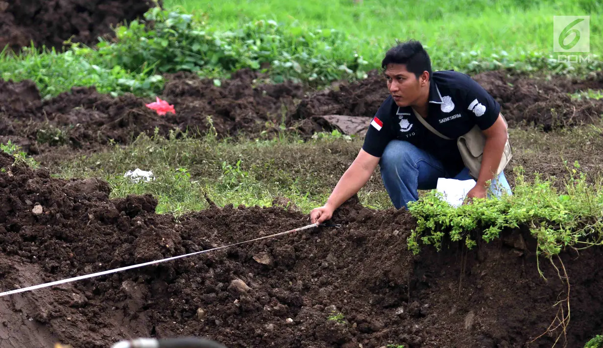 Petugas melakukan pengukuran saat olah TKP longsornya Underpass Perimeter Selatan, Bandara Soekarno Hatta (Soetta), Tangerang, Banten, Selasa (6/2). (Liputan6.com/Angga Yuniar)