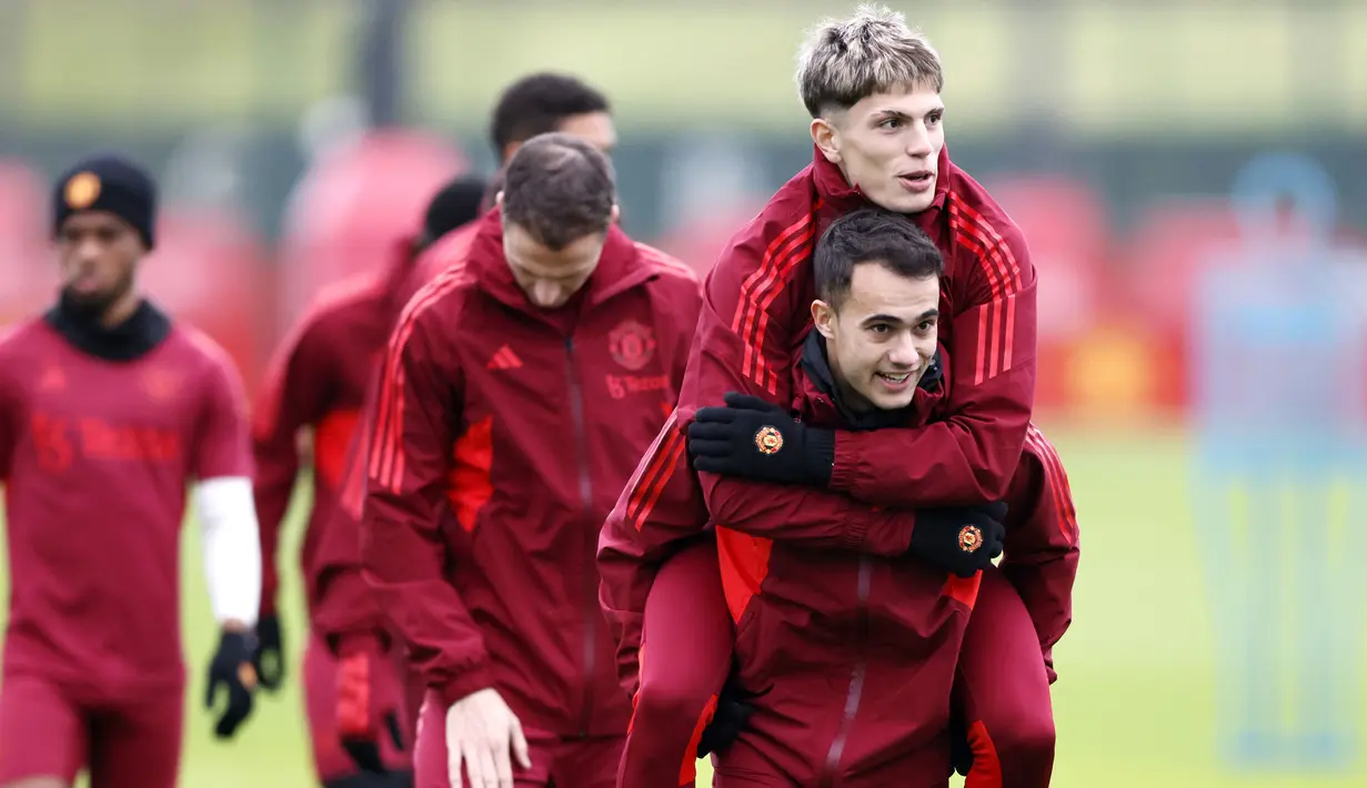 Pemain MU, Sergio Reguilon (kanan), menggendong rekan satu timnya, Alejandro Garnacho dalam sesi latihan yang berlangsung di Carrington, Manchester, Selasa (12/12/2023) dini hari WIB. (AP via PA/Richard Sellers)