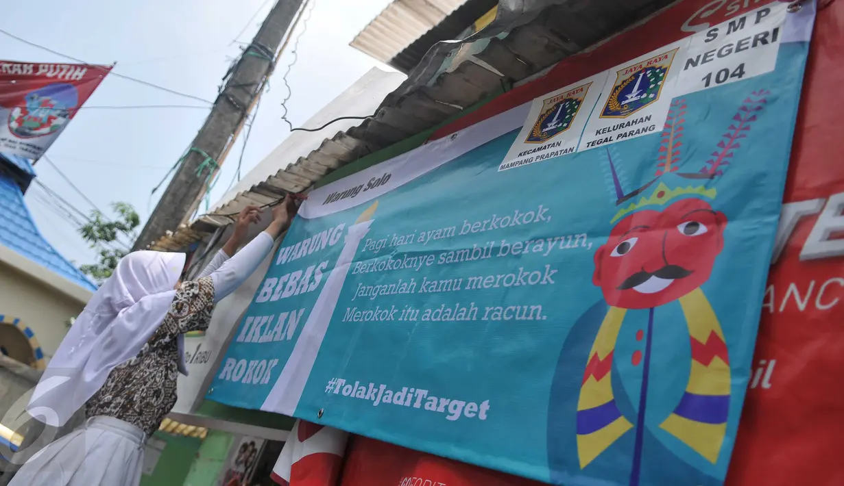 Siswa SMP N 104 Jakarta memasang banner di salah satu warung di kawasan Mampang Prapatan, Jakarta, Kamis (5/11). Aksi ini sebagai bentuk kesadaran tentang ancaman adiksi rokok terhadap anak-anak di sekolah melalui iklan (Liputan6.com/Gempur M Surya)