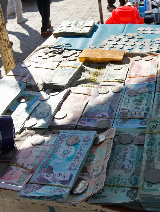 Sejumlah uang kertas Irak yang bergambar mantan Presiden Irak, Saddam Hussein yang dijual disebuah pasar di Baghdad, Irak (28/12). Pada tahun 2003 mata uang yang bergambar Saddam Hussein ini diganti dengan mata uang Dinar Irak yang baru. (AFP/Sabah Arar)
