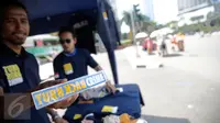Penjual memperlihatkan aksesoris bertulisan "Turn Back Crime" saat Car Free Day kawasan Bunderan HI, Jakarta (13/3).Ini untuk menunjukkan  kepedulian terhadap berbagai tindak kejahatan yang terjadi di lingkungan masyarakat. (Liputan6.com/Faizal Fanani)