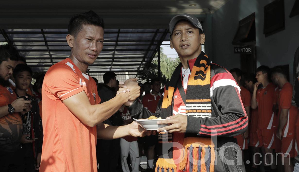 Pemain Persija Jakarta Ismed Sofyan, memberikan nasi tumpeng kepada perwakilan The Jakmania. Di tempat baru ini, pengurus Persija Jakarta berharap pemain bisa lebih dekat dengan para suporter. (Bola.com/M Iqbal Ichsan)