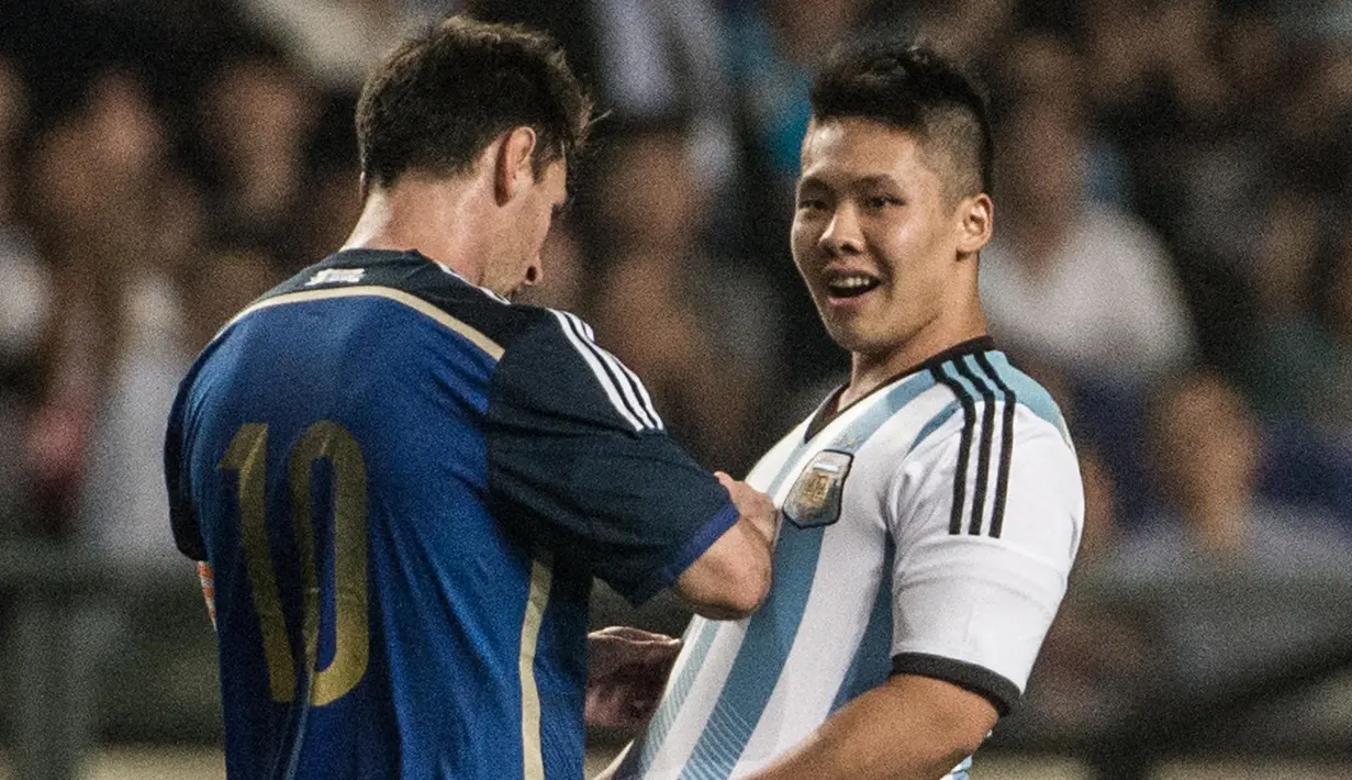 Seorang fan berhasil menyusup ke lapangan hijau dan mendapatkan tanda tangan Lionel Messi saat laga persahabatan antara Hong Kong vs Argentina. ( AFP/Anthony Wallace )