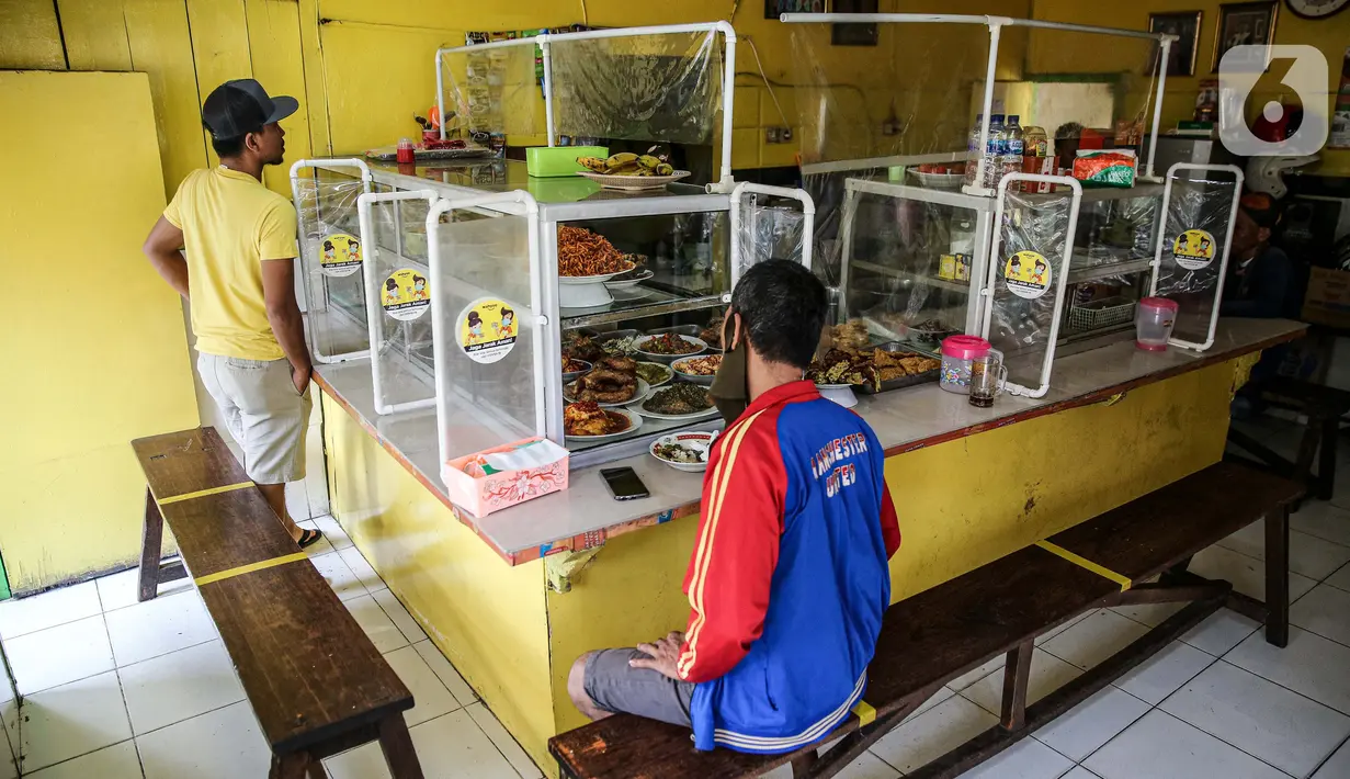 Suasana Warteg Ellya yang menerapkan protokol kesehatan pencegahan penyebaran COVID-19 di Cilandak Timur, Pasar Minggu, Jakarta, Selasa (21/7/2020). Warteg Ellya menerapkan jaga jarak fisik, menyediakan area cuci tangan, mewajibkan pengunjung untuk menggunakan masker. (Liputan6.com/Faizal Fanani)