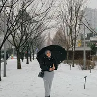 Saat menikmati salju, Aurel tampil cantik dengan outer hitam dan rok abu. Dia terlihat memakai payung agar tidak terkena salju secara langsung