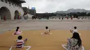 Pengunjung menonton sambil menjaga jarak sosial selama upacara berlakunya kembali pergantian Pengawal Kerajaan di Istana Gyeongbok, salah satu landmark terkenal Korea Selatan, di Seoul, Korea Selatan, Jumat (31/7/2020). (AP Photo/Lee Jin-man)