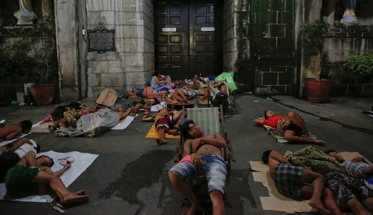 Sejumlah orang tidur di depan sebuah gereja di Manila, Selasa (18/10). Semenjak operasi narkoba Duterte digencarkan, banyak warga Filipina memilih tidur di jalan dan meninggalkan rumah mereka karena khawatir menjadi sasaran. (REUTERS/Damir Sagolj)