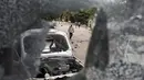 Sebuah mobil tampak hancur akibat bentrokan yang terjadi antara pengunjuk rasa dan polisi di Nikaragua, Kamis (8/10/2015). Para tenaga kerja menolak penutupan tambang emas yang dimiliki oleh Kanada B2Gold Corp . (REUTERS/Oswaldo Rivas)