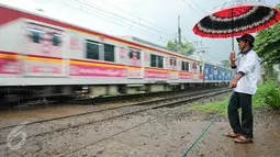 Muhamad Ali, warga Pondok Cina ini mengaku sudah 20 tahun mengatur lalu lintas di perlintasan kereta Pondok Cina. Ia dengan tekun menjaga perlintasan kereta meski tak digaji pemerintah setempat, Depok, Minggu (13/12/2015). (Liputan6.com/Yoppy Renato)