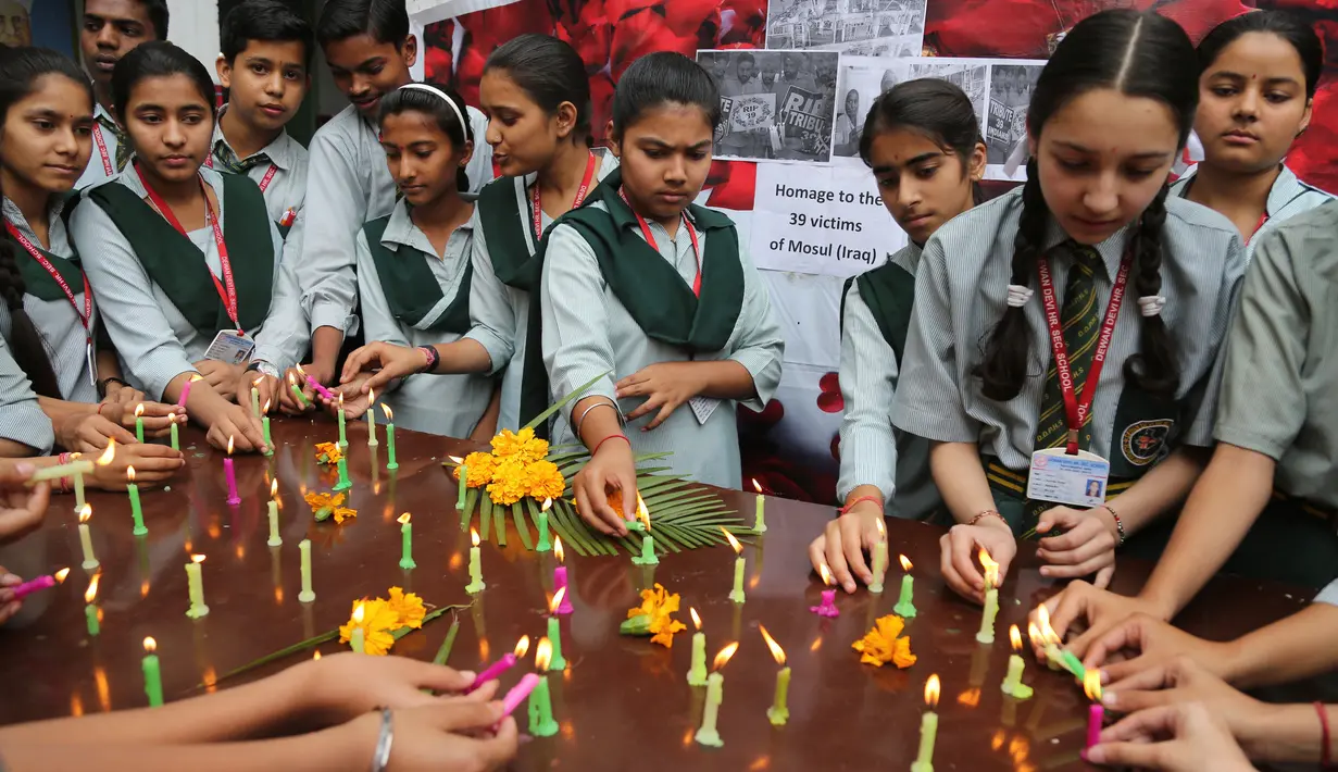 Sejumlah siswa melakukan upacara doa khusus untuk menghormati 39 orang India yang jasadnya ditemukan terkubur di barat laut Mosul, India (21/3). (AP/Channi Anand)