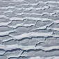 Pemandangan udara terlihat Celah es berbentuk mirip gelombang akibat terus mencair (31/10). Berbagai riset mengatakan fenomena ini disebabkan oleh aktivitas manusia, seperti emisi dari gas rumah kaca. (Mario Tama/Getty Images/AFP)