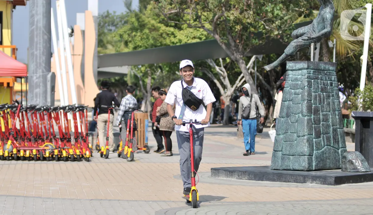 Pengunjung saat berkeliling menggunakan skuter listrik di Pantai Lagoon, Ancol, Jakarta, Rabu (9/10/2019). Pengelola Ancol kini menyediakan penyewaan skuter listrik berbasis aplikasi untuk pengunjung berkeliling kawasan pantai dengan tarif Rp.20.000 per 30 menit. (merdeka.com/Iqbal S. Nugroho)