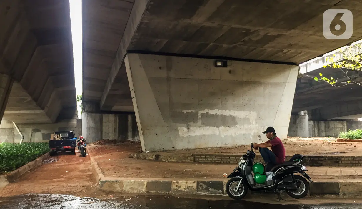 Pengendara motor beristirahat di jalur putar balik Jalan Gatot Soebroto, kawasan Kuningan, Jakarta, Selasa (12/11/2019). Jalur yang kini hanya bisa dilalui kendaraan roda dua itu menjadi lokasi sebagian pemotor beristirahat karena teduh tertutup jalan tol dalam kota. (Liputan6.com/Immanuel Antonius)