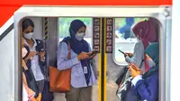 Penumpang melihat ponsel di dalam kereta rel listrik (KRL) saat menunggu keberangkatan di Stasiun Tanah Abang, Jakarta, Rabu (17/1/2023). Sementara itu, total volume pengguna pada weekend sebanyak 3.087.153 orang atau rata-rata sebanyak 617.431 orang. (Liputan6.com/Angga Yuniar)