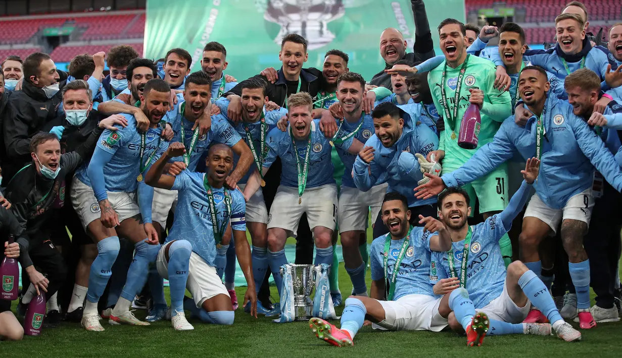 Para pemain Manchester City merayakan gelar Carabao Cup 2020/2021 setelah mengalahkan Tottenham Hotspur pada laga final di Wembley Stadium, London (25/4/2021). Di posisi kedua ada Manchester City yang total telah mengoleksi 8 gelar juara Piala Liga Inggris. Trofi terakhir diraih Manchester Biru pada musim 2020/2021 setelah pada laga final menang 1-0 atas Tottenham Hotspur lewat gol tunggal Aymeric Laporte. (AFP/Pool/Carl Recine)