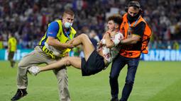 Petugas keamanan menangkap penyusup lapangan ketika pertandingan sepak bola Grup F UEFA EURO 2020 antara Portugal melawan Prancis yang berlangsung di Puskas Arena, Budapest pada 23 Juni 2021. (AFP/Pool/Darko Bandic)