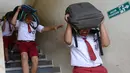 Sejumlah siswa SD menggunakan tas sekolah mereka untuk melindungi diri selama latihan tsunami di Tanjung Benoa dekat Denpasar di pulau resor Bali (15/8). (AFP Photo/ Sonny Tumbelaka)