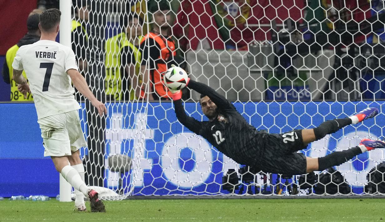 Kiper Portugal, Diogo Costa menggagalkan tendangan pemain Slovenia, Benjamin Verbic pada babak adu penalti saat babak 16 besar Euro 2024 di Frankfurt Arena, Frankfurt, Jerman, Senin (02/07/2024) WIB. (AP Photo/Antonio Calanni)