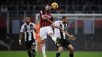 Penyerang muda AC Milan, Cutrone saat melakukan duel udara dengan Chiellini pada lanjutan laga serie a yang berlangsung di stadion San Siro, Milan (12/11). AC Milan kalah 0-2. (AFP/Marco Bertorello)