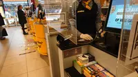 Petugas supermarket terutama bagian kasir wajib menggunakan sarung tangan plastik dan dipasang kaca ektra agar menjaga jarak antara penguntung dan bagian kasir saat melakukan pembayaran ( Foto : Yuke Mayaratih)