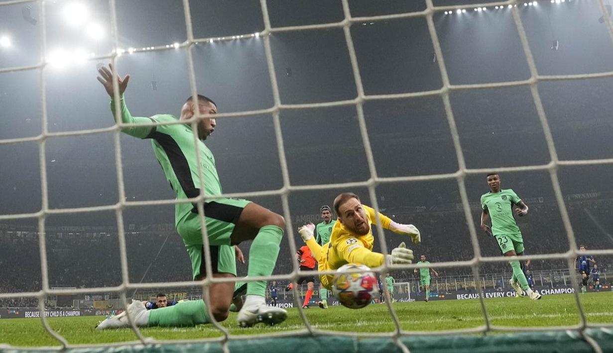 Kiper Atletico Madrid, Jan Oblak gagal menghalau tendangan pemain Inter Milan, Marko Arnaautovic dalam duel leg pertama babak 16 besar Liga Champions di Stadion Giuseppe Meazza, Rabu (21/2/2024). (AP Photo/Luca Bruno)