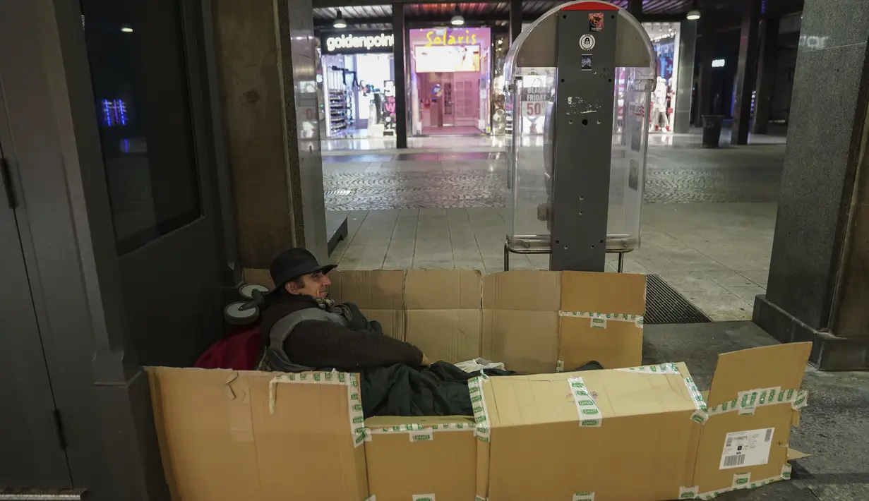 Seorang tunawisma mempersiapkan diri untuk malam hari di pusat kota Milan, Italia utara, 27 November 2020. Tidak ada tempat di Italia yang kemiskinan lebih jelas daripada di Lombardy, wilayah utara yang sempat menjadi episentrum penularan COVID-19. (AP Photo/Luca Bruno)