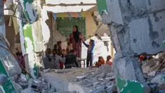 Foto yang dipublikasikan pada 4 Desember 2024 menunjukkan seorang guru Palestina, Doha al-Attar (30) saat memberi pelajaran kepada anak-anak di sebuah ruang kelas yang rusak parah di Khan Yunis, wilayah selatan Jalur Gaza. (Bashar TALEB/AFP)