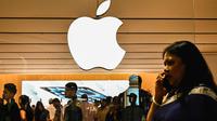 Seorang perempuan berjalan melewati logo raksasa teknologi AS, Apple Inc., yang dipajang di Phoenix Mall pada hari pembukaan toko ritel Apple pertama di Bengaluru pada 2 September 2025. (Idrees Mohammed/AFP)